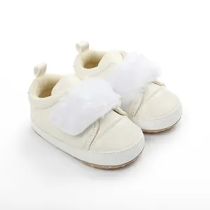 Detailed view of cream baby shoes with white faux fur trim and soft non-slip sole