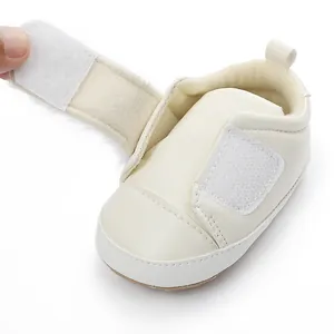 Close-up of white baby princess shoe with plush lining and velcro strap open