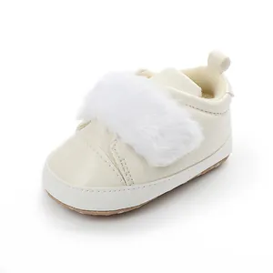Detail of white baby princess shoe with soft faux fur trim and anti-slip sole.