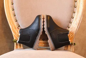 Vista detallada de botines Chelsea negros retro para niños con suela de goma