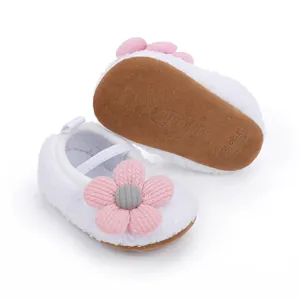 Nahaufnahme weißer Fleece-Babyschuhe mit rosa Blume und weicher, rutschfester Sohle