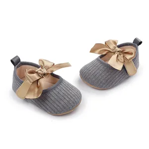 Zapatos de princesa para bebé en punto gris con elegantes lazos de cinta dorada