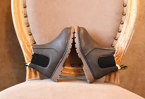 Vista detallada de botines Chelsea grises para niños con suelas de goma antideslizantes.