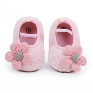 Draufsicht auf rosa flauschige Lauflernschuhe für Babys mit weichen Stoffblumen