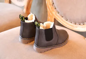 Vista detallada de botas Chelsea marrones para niños con forro cálido y suela blanda flexible