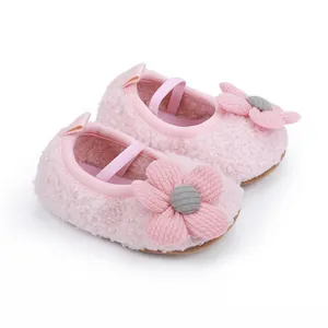 Nahaufnahme von rosa flauschigen Babyschuhen mit süßer Blume und weicher Sohle