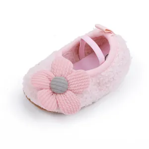 Detail eines weichen rosa flauschigen Babyschuhs mit dekorativer Strickblume und Band