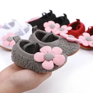 Close-up of soft-soled baby cotton shoes with a fluffy texture and pink flower detail