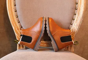 Vista detallada de botas retro marrones para niños con un forro cálido de felpa blanca