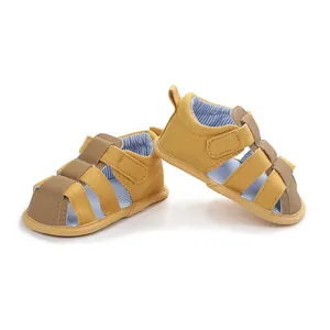 Primer plano de sandalias amarillas transpirables para bebé con forro a rayas y velcro