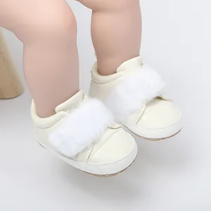 Detailed view of cream baby girl princess shoes with soft soles and white faux fur trim.