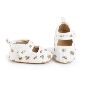 Detail of white ribbed baby walking shoes with gold heart patterns for 0-1 year olds