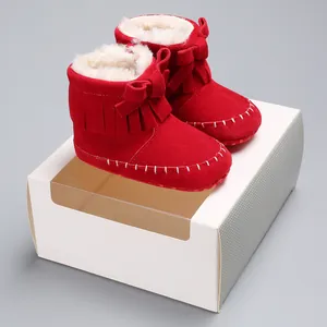 Detailed view of red baby fringe boots with warm faux fur lining and decorative bow