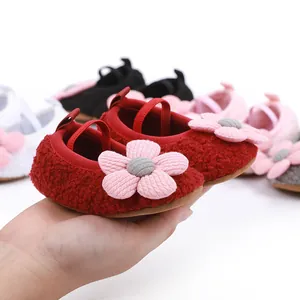 Detail of soft-soled baby shoes featuring plush flower design in multiple colors
