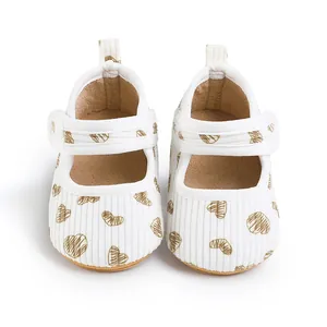 Front view of infant walking shoes featuring brown heart patterns on white corduroy fabric