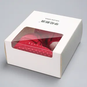 Red fringe baby walking shoes with white polka dots presented in a window gift box detail