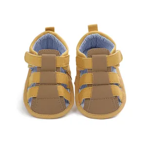 Vista frontal de sandalias de lona para bebés en amarillo y marrón con forro azul