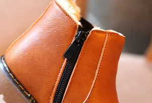 Detalle de cremallera duradera y forro polar cálido en botas retro marrones para niños