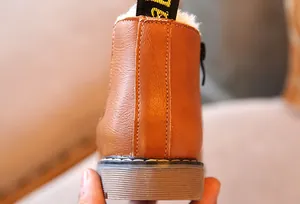 Detalle posterior de las botas Martin de cuero marrón para niños con forro de felpa blanca