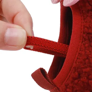 Close-up view of the elastic strap on red soft-soled cotton shoes for infants