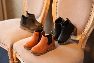 Vista detallada de los botines Chelsea para niños en colores negro, marrón y beige