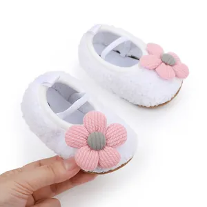 Close-up of white fleece baby walking shoes featuring a soft sole and pink flower decor