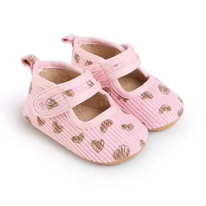 Close-up of pink baby walking shoes with cute heart prints and easy Velcro strap detail