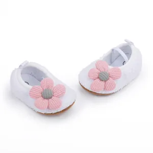 Detail view of white soft-soled fleece baby walker shoes with pink flower decoration