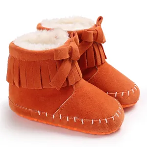 Detailed view of orange baby fringe boots featuring soft soles and plush lining