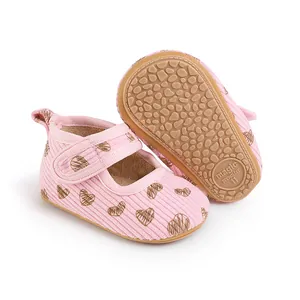 Close-up detail of pink baby prewalker shoes with heart pattern and anti-slip rubber sole.