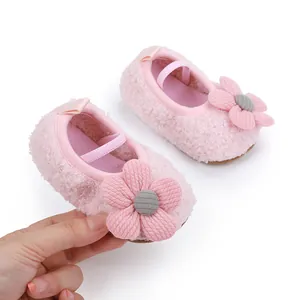 Close-up of pink plush baby walking shoes with decorative fabric flower detail