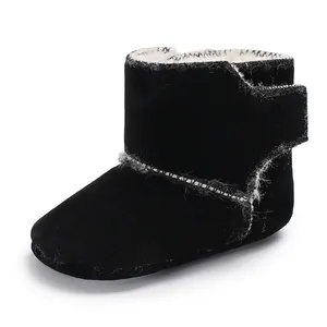 Detail van een zwarte suède babyschoen met zachte imitatiebontvoering en klittenband