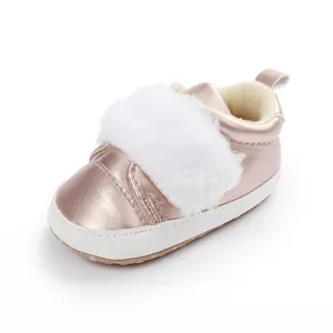 Close-up of rose gold baby princess shoes with white faux fur trim and soft white sole.