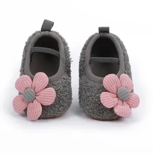 Nahaufnahme grauer Baby-Lernlaufschuhe aus Fleece mit weichen Sohlen und rosa Blumenakzent