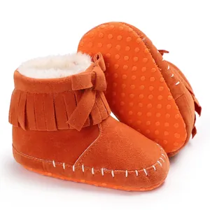 Close-up of orange baby fringe boots with warm faux fur lining and anti-slip sole