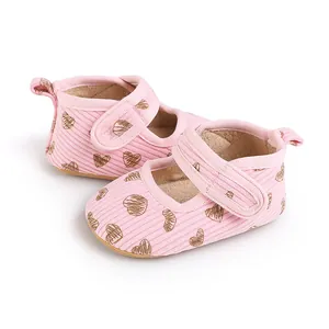 Detailed view of pink baby walking shoes with brown heart patterns and velcro strap
