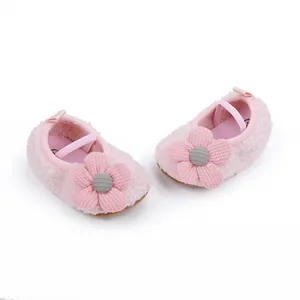 Macro view of pink fuzzy baby shoes with soft soles and decorative fabric flowers