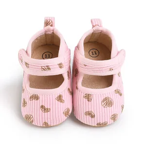 Adorable pink baby walking shoes with brown heart pattern and velcro strap detail
