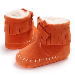 Detail view of orange baby fringe boots with soft plush lining and cute bow accent.