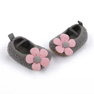 Detailansicht grauer Baby-Lauflernschuhe mit großen rosa Dekoblumen und weicher Sohle