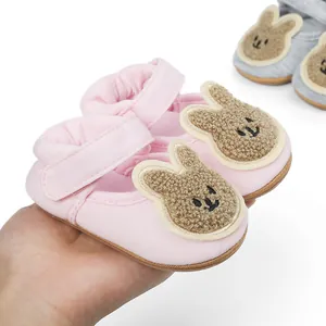 Detailed macro view of soft pink baby walking shoes with cute fuzzy bunny character ears
