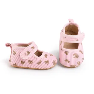 Detail shot of pink baby walking shoes with brown heart pattern and soft strap