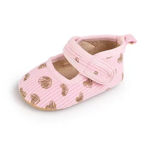 Detailed view of pink baby pre-walker shoe featuring brown heart patterns and velcro strap