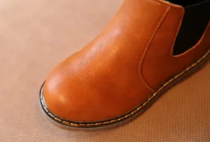 Primer plano de bota Martin de cuero marrón mostrando costuras y detalle de textura