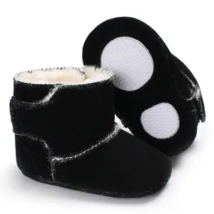 Detail van zwarte suède babylaarzen met warme bontvoering en zachte rubberen zool.