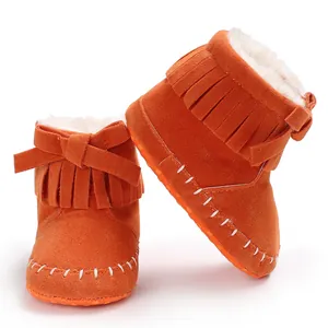 Close-up of orange fringed baby boots featuring soft soles and warm faux fur lining