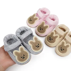 Detalle de zapatos de algodón para bebé con un lindo parche de conejo animado