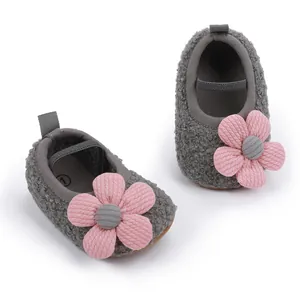 Detailaufnahme der weichen grauen Fleece-Babyschuhe mit rosa Blumenverzierung