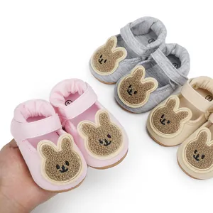 Primer plano de suaves zapatos para caminar de bebé con conejo en rosa, gris y beige