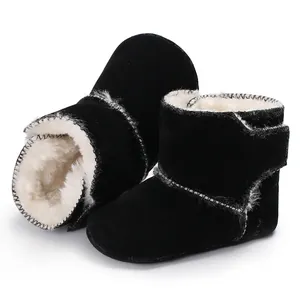 Gedetailleerde weergave van zwarte babyboots van mat leer met warme witte imitatiebontvoering.
